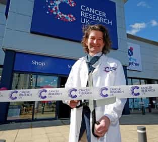Richard Martin stood in front of CRUK superstore for opening with ribbon